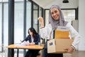 A cheerful Asian Muslim businesswoman is showing her fist, feeling happy to quit her job Royalty Free Stock Photo