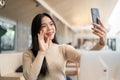 A beautiful Asian woman taking selfies with her smartphone while relaxing in a coffee shop Royalty Free Stock Photo