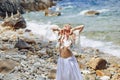 Beautiful young boho style woman in white dress on stone beach Royalty Free Stock Photo