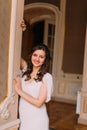 Beautiful and cheerful young bride posing in luxurious vintage interior near doorcase Royalty Free Stock Photo