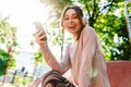 Beautiful cheerful young fitness sports woman posing outdoors in park listening music with earphones using mobile phone Royalty Free Stock Photo