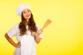 Beautiful chef - cute brunette woman in cook uniform over yellow