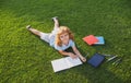 Beautiful child boy writing on notebook on grass background. Kids reading book in park. Concept of kids learning, study Royalty Free Stock Photo