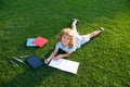 Beautiful child boy writing on notebook on grass background. Kids reading book in park. Concept of kids learning, study Royalty Free Stock Photo