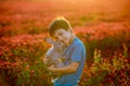 Beautiful child with cute bunny in gorgeous crimson clover field on sunset Royalty Free Stock Photo