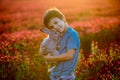 Beautiful child with cute bunny in gorgeous crimson clover field on sunset Royalty Free Stock Photo