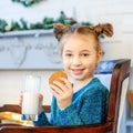 A beautiful child drinks milk and eats oatmeal cookies at home. Royalty Free Stock Photo