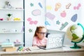 beautiful child in eyeglasses using laptop while studying at desk at home welcome back Royalty Free Stock Photo