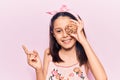 Beautiful child girl holding cookie smiling happy pointing with hand and finger to the side Royalty Free Stock Photo