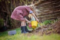 Beautiful child girl in spring garden plays and planting hyacinth flowers