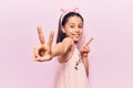 Beautiful child girl wearing casual clothes smiling looking to the camera showing fingers doing victory sign Royalty Free Stock Photo