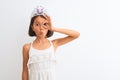 Beautiful child girl wearing princess crown standing over isolated white background doing ok gesture shocked with surprised face, Royalty Free Stock Photo