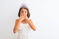 Beautiful child girl wearing princess crown standing over isolated white background shocked covering mouth with hands for mistake Royalty Free Stock Photo