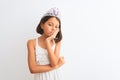 Beautiful child girl wearing princess crown standing over isolated white background thinking looking tired and bored with