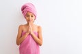 Beautiful child girl wearing shower towel after bath standing over isolated white background praying with hands together asking Royalty Free Stock Photo