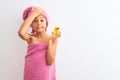 Beautiful child girl wearing shower towel holding duck over isolated white background stressed with hand on head, shocked with Royalty Free Stock Photo