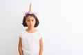 Beautiful child girl wearing unicorn diadem standing over isolated white background depressed and worry for distress, crying angry