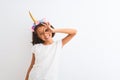 Beautiful child girl wearing unicorn diadem standing over isolated white background doing ok gesture with hand smiling, eye Royalty Free Stock Photo