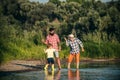 Beautiful child with Parents throws a rock at the river. Skipping Rocks. Three generation family. Royalty Free Stock Photo