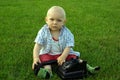 Beautiful child with phone on the green grass