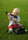 Beautiful child with phone on the green grass