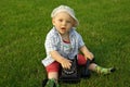 Beautiful child with phone on the green grass