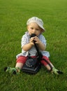Beautiful child with phone on the green grass