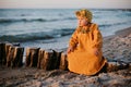 Beautiful child sitting on breakwater on baltic sea beach Royalty Free Stock Photo