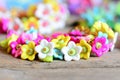 Beautiful children bracelet on vintage wooden table. Bracelet made of colourful plastic flowers, leaves and beads