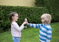 Beautiful children 6-7 years old in park, the boy gives the girl daisy flowers Royalty Free Stock Photo