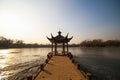 Beautiful Chinese gazebo in the middle of a frozen lake in the park on a background of trees Royalty Free Stock Photo