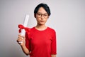 Beautiful chinese student woman wearing glasses holding university graduated diploma degree with a confident expression on smart Royalty Free Stock Photo