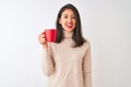 Beautiful chinese woman drinking red cup of coffee standing over isolated white background with a happy face standing and smiling Royalty Free Stock Photo