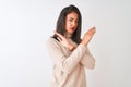 Beautiful chinese woman wearing turtleneck sweater standing over isolated white background Rejection expression crossing arms Royalty Free Stock Photo