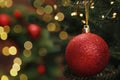 Beautiful Christmas ball hanging on fir tree branch against blurred background, closeup. Space for text Royalty Free Stock Photo