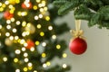 Beautiful Christmas ball hanging on fir tree branch against blurred lights, closeup. Space for text Royalty Free Stock Photo