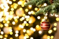 Beautiful Christmas ball hanging on fir tree branch against blurred lights, closeup. Space for text Royalty Free Stock Photo