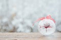 Beautiful Christmas bauble decorations lie on the wooden table over snow covered forest background Royalty Free Stock Photo