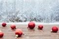 Beautiful Christmas bauble decorations lie on the wooden table over snow covered forest background Royalty Free Stock Photo