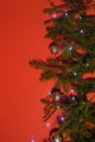 A beautiful Christmas card, a tree with New Year's decorations and a garland on a bright, red background Royalty Free Stock Photo