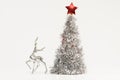 Beautiful Christmas composition of a deer silver figurine and lush silver Christmas tree