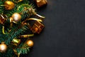 Christmas composition with fir branches and golden decorations on black background. Flat lay, top view, copy space. Merry Christma