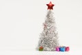 Beautiful Christmas composition with a lush silver Christmas tree and colorful gift boxes Royalty Free Stock Photo