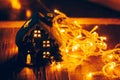 Beautiful Christmas decoration with tangerines and a toy house in the night light garlands. Citrus still life Royalty Free Stock Photo