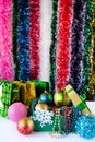 Beautiful Christmas decorations, toys, beads, balls in a box in foreground. Behind them there are gift bags
