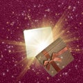 Beautiful Christmas gift box with magic light on sparkling background Royalty Free Stock Photo