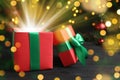 Beautiful Christmas gift box with magic light on table. Bokeh effect Royalty Free Stock Photo