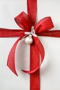 Beautiful Christmas gift present with bright red bow and silver wrapping paper background Royalty Free Stock Photo