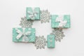 Beautiful christmas gifts and silver snowflakes isolated on white background. Turquoise colored wrapped xmas boxes.