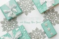 Beautiful christmas gifts and silver snowflakes isolated on white background. Turquoise colored wrapped xmas boxes.